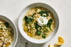 two bowls filled with soup and topped with sour cream, lemon wedges and parsley