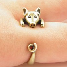 a close up of a person wearing a ring with a dog on it's face