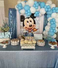 a mickey mouse party with balloons and desserts