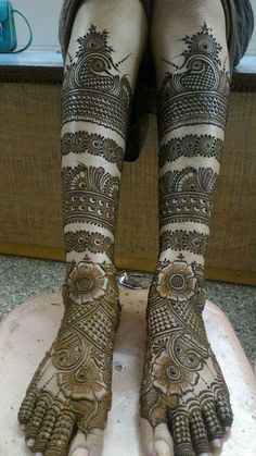 the legs and feet of a woman with henna tattoos