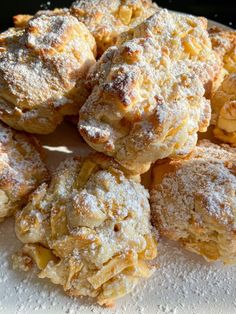 a pile of powdered sugar covered pastries sitting on top of a table