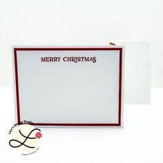 a christmas card with the word merry christmas written in red and white on it next to an envelope