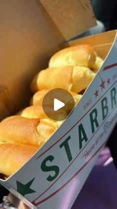 a box filled with lots of bread on top of a purple tablecloth covered floor