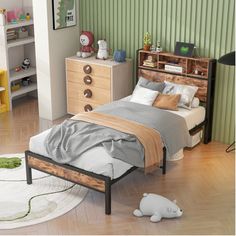 a child's bedroom with green striped walls and wooden furniture, including a bed