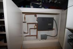 an electrical box in the corner of a kitchen with pipes running from it to the floor