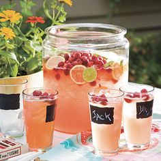 four glasses filled with drinks sitting on top of a table