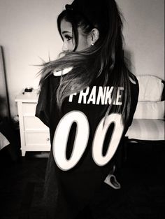 a woman with long hair wearing a t - shirt that says franke 00