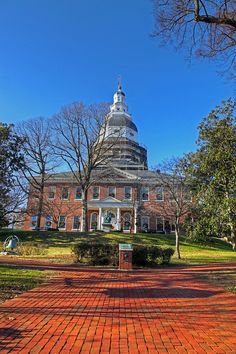 an old brick building with a dome on top in the middle of trees and grass