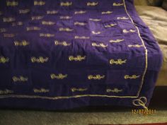 a purple blanket sitting on top of a bed