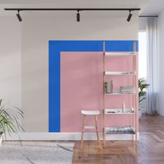 a living room with pink and blue paint on the wall, bookshelf and plant