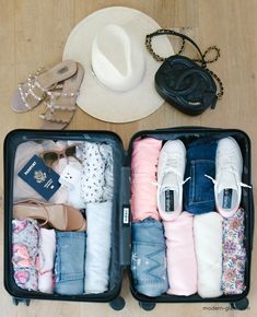 two suitcases filled with clothes and shoes on top of a wooden floor next to a hat