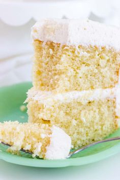 a slice of white cake on a green plate with a fork in front of it