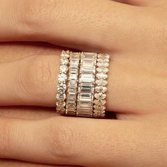 a woman's hand with three stacked rings on her fingers and one ring in the middle