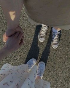 two people holding hands while standing next to each other