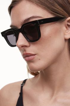 The 04 Sunglasses in Black by CHIMI are a stylistic silhouette creating dynamic contrast with a strong rectangular frame and slim sides. Handcrafted in Mazzucchelli acetate with silver-tone hardware rivets and pointed temple tips, finished with deep bevel cuts along the UV-protective CR39 lenses. Each pair comes with a branded case, pouch and cleaning cloth. Sizing + Details → 100% Acetate 100% UVA+UVB Protection Medium Reduction Of Sun Glare Anti-Scratch, Anti-Shatter, Distortion-Free Frame 142mm, Nose 24mm, Temple Lens 145mm, Lens Thickness 2mm Sleek Black Wayfarer Sunglasses, Contemporary Black Polarized Sunglasses, Modern Black Square Frame Sunglasses, Modern Black Acetate Sunglasses, Contemporary Black Sunglasses With Gradient Lenses, Black Acetate Wayfarer Sunglasses, Metal Core, Free Frames, Eyewear Womens