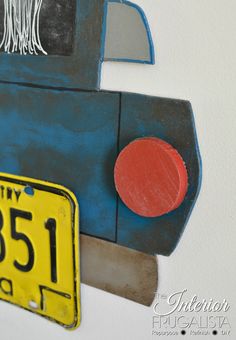 a close up of a sign on a wall with a car painted on it's side