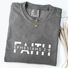 "Faith Shirt, Religious Shirt, Christian Comfort Colors Shirt, Bible Verse Shirt, Religion Shirt, Christian Tshirt, Jesus Tee, Comfort Colors" T-Shirt adds a playful twist, making it a great conversation starter. 🌿WELCOME TO BestieFL If you are looking for soft, comfy, first-rate t-shirts, you're in the right place! Here at Best Wishes From FL , we love what we do and strive to make your shopping experience just right for you. If you have any questions, concerns, or comments about our products, Church T Shirt Designs, Cotton T-shirt With Faith Text Print, Gray Cotton Tops With Name Print, Christian Comfort, Christian Tshirt Design, Christian Tshirt, Shirt Sayings, Bible Verse Shirt, Jesus Tees