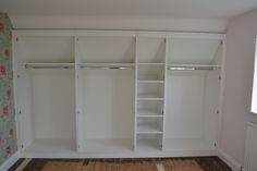 an empty room with white closets and wooden floors