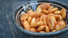 a bowl filled with fried food on top of a wooden table