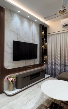 a modern living room with marble walls and white table in front of the flat screen tv