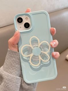 a woman is holding up her phone case with a flower on the front and bottom