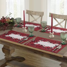 a dining table set with place mats and red candlesticks for christmas or new year's eve