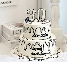 a three tiered cake with the number 30 on it's icing and lettering