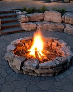 a fire pit sitting in the middle of a stone walkway next to steps and stairs