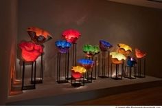 a group of different colored vases sitting on top of a table next to each other