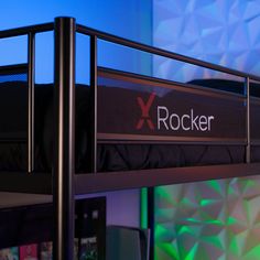 a black metal bunk bed with the word rocker on it's side and green lights in the background