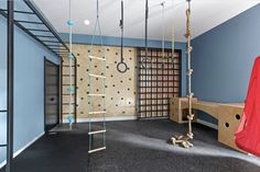 an empty play room with swings and climbing ropes