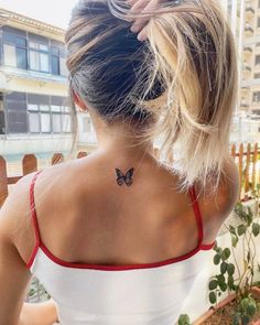 a woman with a butterfly tattoo on her back