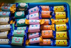 there are many candy wrapped in different colors and designs on the tray, with faces drawn on them