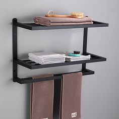 two black shelves holding towels and other items