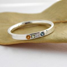 This Multi-stone Inside Out Ring is made from sterling silver and can be set with your choice of stones. The ring is formed from a dome wire that is turned inside out with the domed part on the inside. It gives the ring a look of a smooth rectangular band but with the fit of a comfort band ring. Each ring is completely handcrafted and then polished before the stone is set. Due to the customization combination of stones this ring is NOT returnable. Any ring size adjustments will require an additi Sterling Silver Stackable Topaz Ring Gift, Sterling Silver Gemstone Toe Ring, Sterling Silver Birthstone Ring For Everyday, Dainty Sterling Silver Crystal Ring With Accent Stones, Hallmarked Sterling Silver Stackable Rings, Everyday Sterling Silver Birthstone Ring With Gemstone, Sterling Silver Gemstone Toe Rings Stackable, Sterling Silver Gemstone Stackable Promise Rings, Adjustable Sterling Silver Birthstone Ring