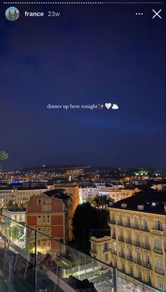 the city lights shine brightly in the night sky as seen from an elevated balcony with glass railings