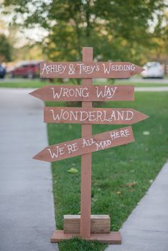 a wooden sign that says, wedding wrong way wonderland we're all here