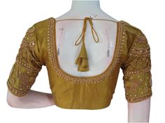 Elevate your saree ensemble with this exquisite tissue mustard Aari handwork blouse. The intricate gold embroidery and delicate beadwork create a stunning and timeless piece. This ready-to-wear blouse is perfect for any special occasion and ensures a hassle-free fit. * This Is A Fully Stitched Saree Blouse, Ready To Wear * Made of Tissue silk, Lined With Cotton * Opens From Front With Hook and eye-fitting MEASUREMENTS: Sleeve: 10 inches  Size: 38,40,42 Blouse Length: 15 inches  Neck Depth: Front Gold Silk Saree With Intricate Embroidery, Gold Silk Embroidered Traditional Wear, Gold Embroidered Silk Traditional Wear, Traditional Yellow Raw Silk Wear With Gold Embroidery, Traditional Gold Embroidered Silk Wear, Gold Art Silk Blouse Piece For Reception, Gold Blouse Piece With Resham Embroidery For Navratri, Gold Art Silk Blouse For Reception, Gold Traditional Wear With Silk Thread Zari Work