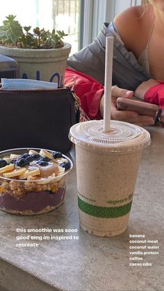 a woman sitting at a table next to a bowl of food and a cup of coffee