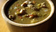 a wooden bowl filled with soup on top of a table