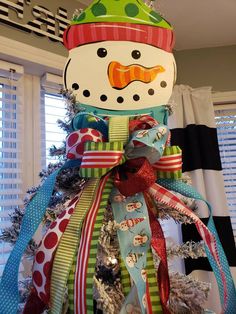 a snowman made out of ribbons on top of a christmas tree