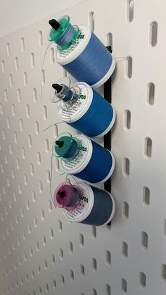 three spools of thread are hanging on the wall