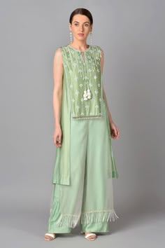 Mint green asymmetric tunic with floral embroidered motifs, front tassel tie-up. Paired with organza tassel layered palazzo.
Component: 2
Embroidered
Neckline: Round
Sleeve Length: Sleeveless
Fabric: Chanderi Silk, Organza
Color: Green
Front tassel tie-up
Layered palazzo - Aza Fashions Pakistani Velvet Suits, Organza Kurta, Asymmetric Tunic, Saree Blouse Styles, Embroidery 3d, Raw Silk Fabric, Embroidered Motifs, Fancy Kurti, Kurta Neck Design