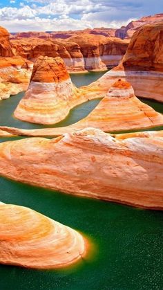 the water is green and brown in this desert area with large rocks on both sides