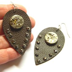 Dangling earrings made of authentic old clockworks upon leaf dark brown chocolate leatherette inlaid with crystals. Charming piece of industrial jewelry. Gorgeous steampunk earrings, they will arrive in a nice box and can make fantastic birthday gift. The clock mechanism resembles a bird, a peacock... Total length - 2 3/4" / 7 cm Dimensions of the old clockworks 5/8" / 1.5 cm diameter Dimensions of the faux leather leaf 2 1/4" x 1 1/4" / 5.6 cm x 3.2 cm approximately A jeweler's alloy, colored in golden or silver or bronze tones, was used for the production. Not precious metals used - gold or sterling silver or platinum! More steampunk earrings: https://www.etsy.com/ru/shop/EmilySteampunk?section_id=14485465 Emily Steampunk shop https://www.etsy.com/shop/EmilySteampunk Please take a moment Steampunk Shop, Steampunk Christmas, Steampunk Earrings, Industrial Jewelry, Leather Leaf, Steampunk Diy, Brown Chocolate, Jewelry Birthday, Birthday Jewelry Gift