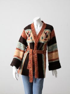 "This is a 1970s vintage hippie sweater.  The boho knit cardigan wraps closed with knit belt.  A multi colored patterned sweater in dark brown, rust, tan, and green tones. It has belled sleeves.  The sweater is 100% acrylic with label Korea WPL 12010. CONDITION In good condition with wear consistent with age and use.  MARKED SIZE: S APPROXIMATE FIT:  S MEASUREMENTS Bust:  34\"  ...  86.4 cm Length:  28.5\"  ..  72.4 cm Shoulders:  16\"  ...  40.6 cm Outside Sleeve:  20.5\"  ..  52.1 cm  922101" Boho Knitted Cardigan, Hippie Sweater, 1970s Sweater, Knit Belt, Dark Brown Dress, Hippie Sweaters, Boho Knit, Patterned Sweater, 70s Hippie