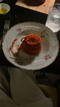 a white plate topped with spaghetti on top of a table