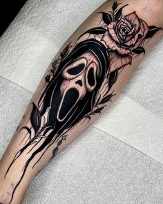 a black and white tattoo with a rose on the arm, skull and crossbones