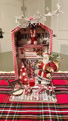 a table topped with christmas decorations and candy canes on top of a red checkered table cloth