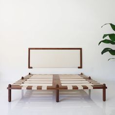 a bed with a wooden frame and white sheets